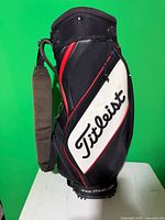 Left side view showing Titleist logo panel, red trim, padded shoulder strap, molded base