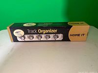 Front of boxed Home It Track Organizer showing product image and branding
