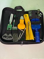 All watch repair tools arranged inside open black zippered case