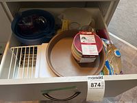 Drawer view showing all items including prep bowls, cooling rack, cake pan, mixing bowls and accessories