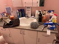 Countertop with HappyLight, scale, hair dryer, pouf, squeegee and many bottles visible