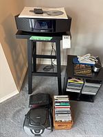 Full lot view showing Bose system on stand, CD rack, boombox, portable CD player and CDs