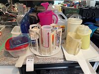 Group shot of all plastic containers, pitchers, canisters, organizer and cutting boards on counter