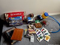 Group shot showing Scrabble board game, jigsaw puzzle, books, cube, pump, skipping rope and other items
