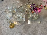 Overall view of assorted clear and amber glass items on floor