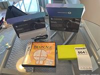 Lot overview showing two boxed Starscope monoculars, lime green Nintendo DS console and Brain Age game