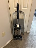Vacuum and folded step stool leaning against wall