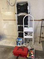 All items grouped: two ladders, Arctic Air box, toolbox, cords, bin