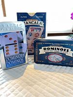 Three boxed games: Classic Games dominoes, solid wood mancala, collector dominoes tin