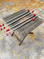 Four red pipe clamps laid on table, full view
