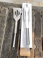 Spatula and boxed fork on wooden surface