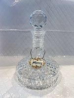 Front view of crystal decanter with stopper and sherry tag attached