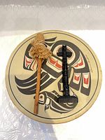 Drum top view with beater and totem pole on surface