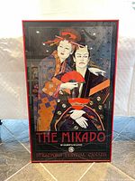 Front view showing The Mikado poster artwork, text, red metal frame