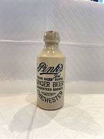 Front view of stoneware bottle showing full advertising text