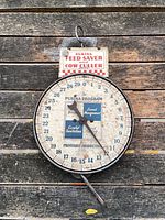 Front view of Purina hanging scale showing dial and branding