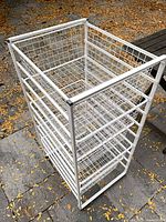 Oblique view of entire white wire rack with five baskets