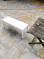 Full view of white IKEA bench on patio