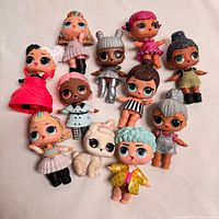 Group shot of 11 LOL Surprise dolls and one pet on white background
