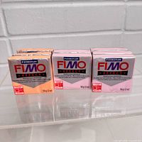 Front view of three sealed FIMO Effect clay blocks showing colours and packaging.