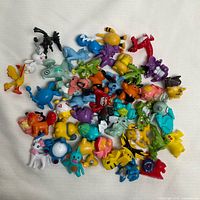 Top view of entire assortment of Pokemon figures spread on white surface