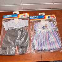 Two sealed Diana doll clothing outfits side by side in packaging