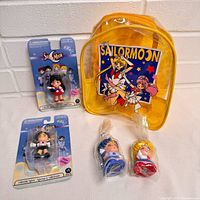 Group shot of backpack, two carded figures, two bagged chibi figures