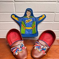 Front view of Superman slippers and Captain Shakee puppet