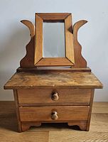 Front view of wooden doll dresser, mirror upright, drawers closed