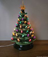 Full view of illuminated ceramic Christmas tree on base