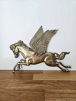 Full view of brass Pegasus wall hanging against white background