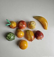Group shot of nine alabaster fruits on white surface
