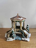 front view of ceramic gazebo with bridge and snow accents