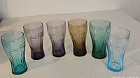 Group shot of six colored Coca-Cola glasses