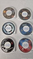 All six PSP UMD game discs arranged in two columns, labels visible