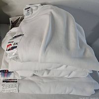 Stack of three folded white Jerzees sweatshirts with tags visible