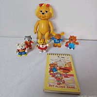 Group shot of Dotty Dog doll, five mini figures, memo pad