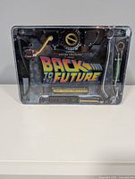 Front view of sealed metal case showing Back to the Future branding