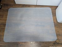 Full view of clear PVC chair mat on hardwood floor