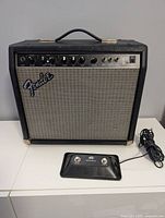 Front view of Fender Champion 110 amplifier with Peavey footswitch and cable