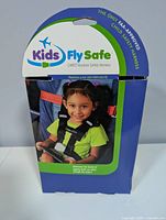 Front of Kids Fly Safe CARES retail box showing product name and child using harness