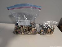 Two resealable plastic bags filled with mixed costume jewelry pieces