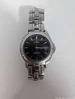 Front view of Seiko wristwatch displaying black dial, date window and bracelet