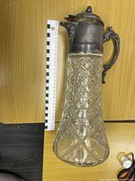 Full view of pitcher standing beside metric scale showing height and overall design