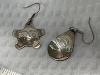 Front view of both earrings showing carved designs