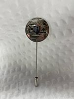 Front view of carved silver face stick pin