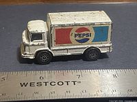 Left side and front view of Corgi Pepsi truck beside ruler showing length
