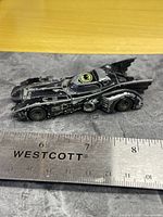 Left side view of Ertl Batmobile beside ruler showing length