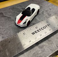 Top three-quarter view of die-cast car beside ruler