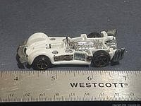 Side view of white Hot Wheels Road Rocket beside ruler showing length
